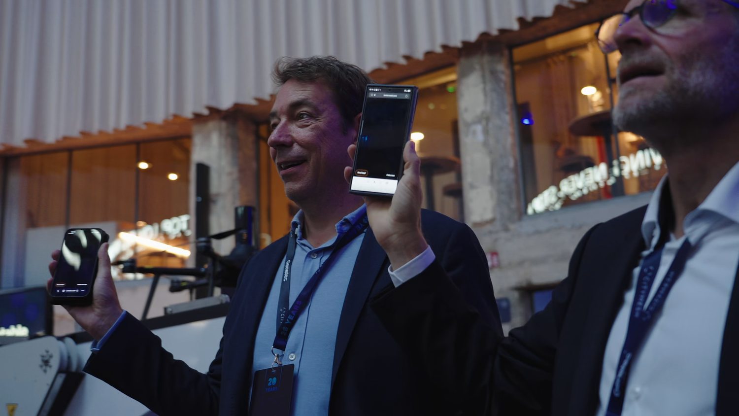 Two guests holding up their phones, now live pixels in the Lumicrowd show
